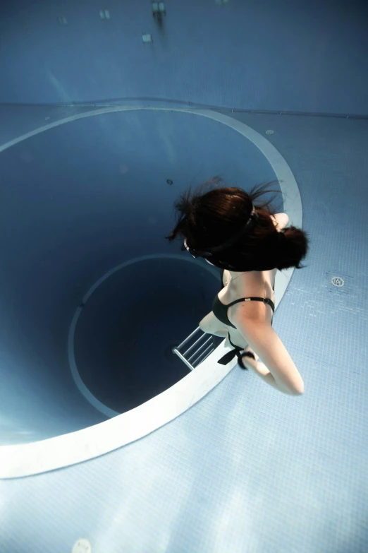 a woman is standing in the middle of a round pool