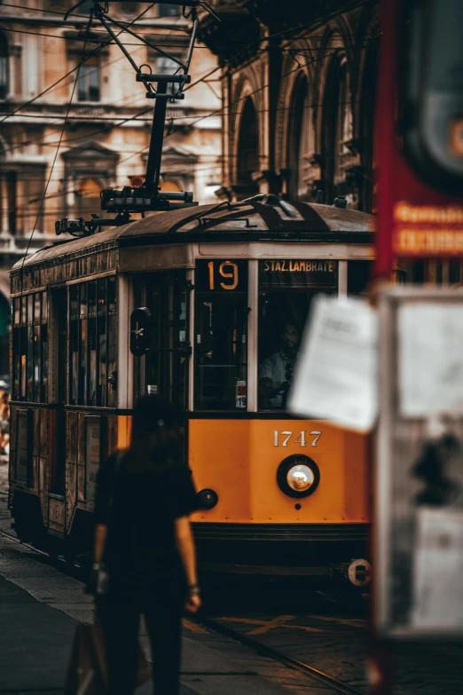 a yellow trolley traveling down a street next to tall buildings, pexels contest winner, viennese actionism, profile image, vintage aesthetic, italian, thumbnail