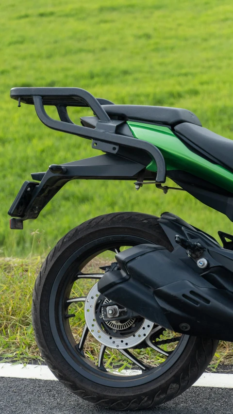 a green motorcycle parked on the side of the road, by Tom Scott RSA, shutterstock, close-up shot from behind, square, high tech saddle, 15081959 21121991 01012000 4k