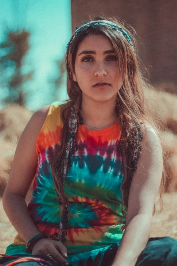 a woman sitting on the ground in a tie dye dress, a portrait, inspired by Elsa Bleda, trending on pexels, wearing a vest top, native american, closeup portrait shot, rasta
