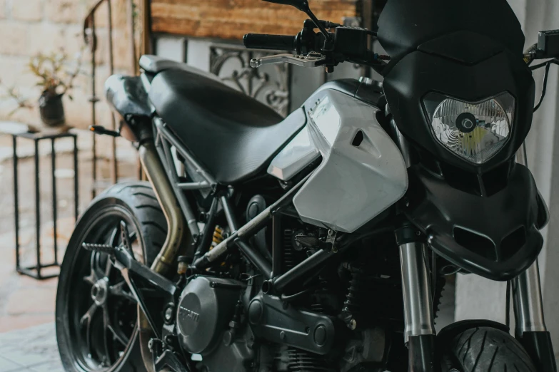 a black and white motorcycle parked in a garage, avatar image, fan favorite, white mechanical details, laica chrose