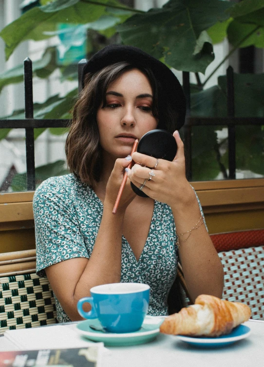 a woman sitting at a table looking at her cell phone, a portrait, by Julia Pishtar, trending on pexels, putting makeup on, french bob, coffee, avatar image