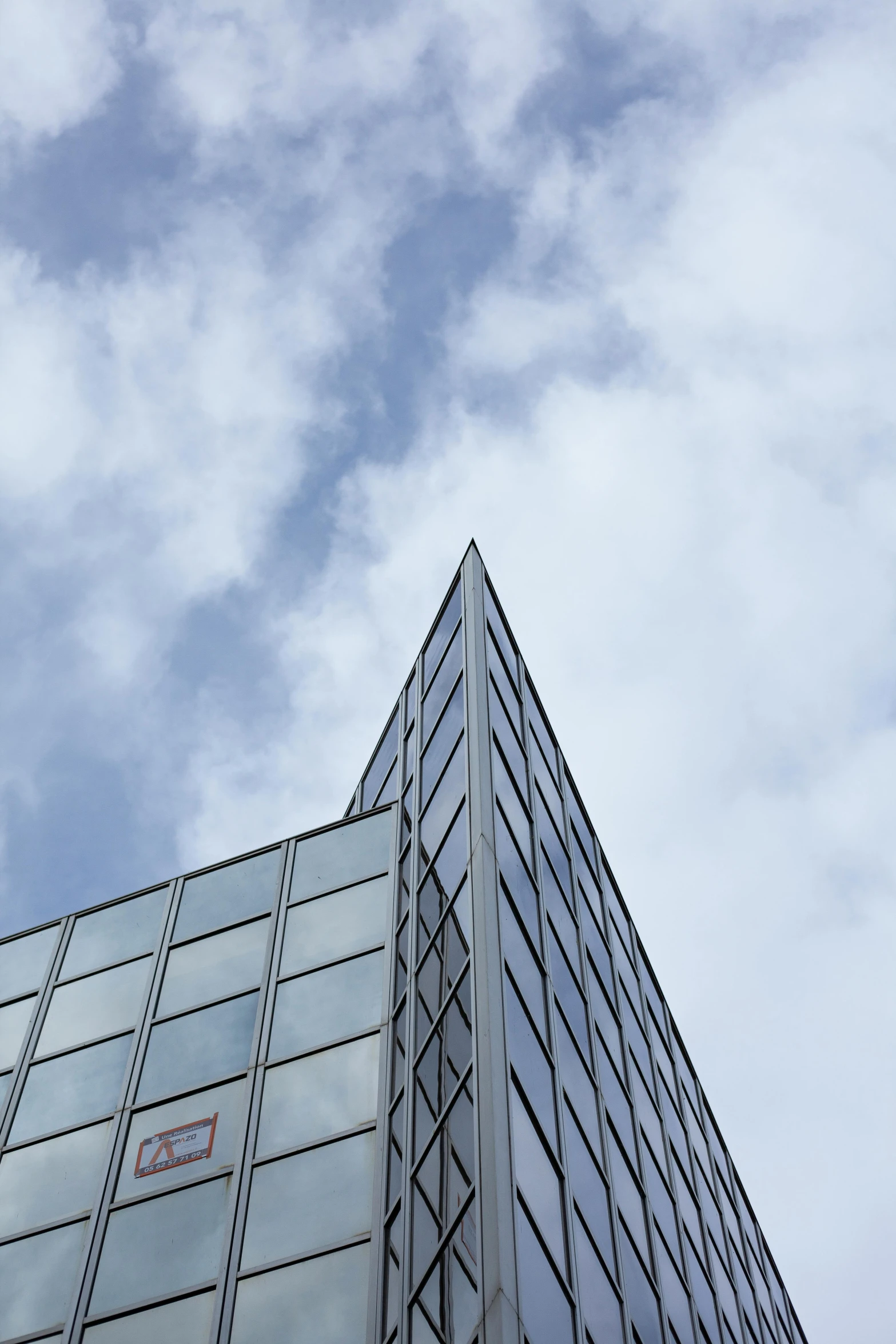 a tall building with a clock on the side of it, a photo, inspired by Tadao Ando, unsplash, cloud day, triangle, corners, high quality photo