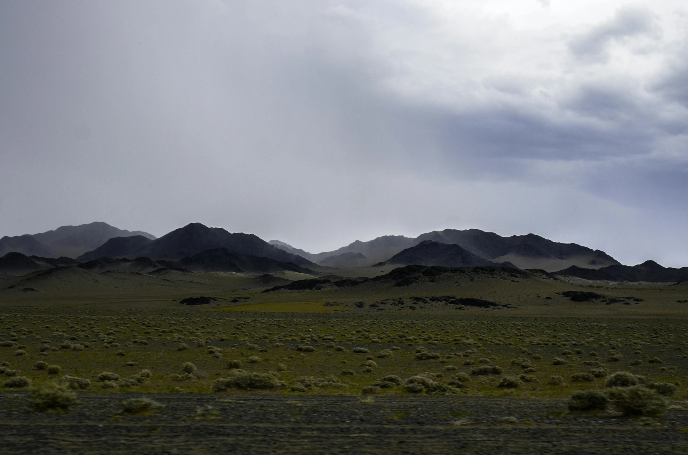 mountain view of a grassy field with mountains in background