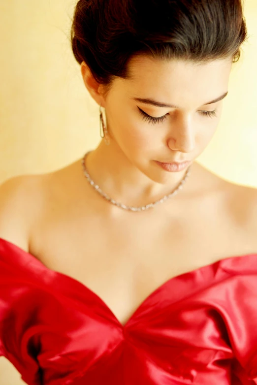 a woman in a red dress looking down, elegant gleaming jewelry, istockphoto, rachel weisz, dreamy soft