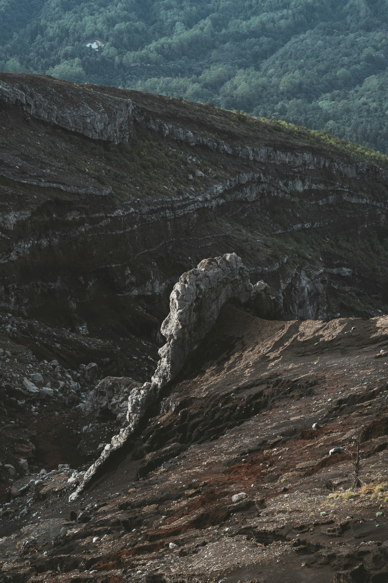 the view of a rock and grass covered hillside from a hill side