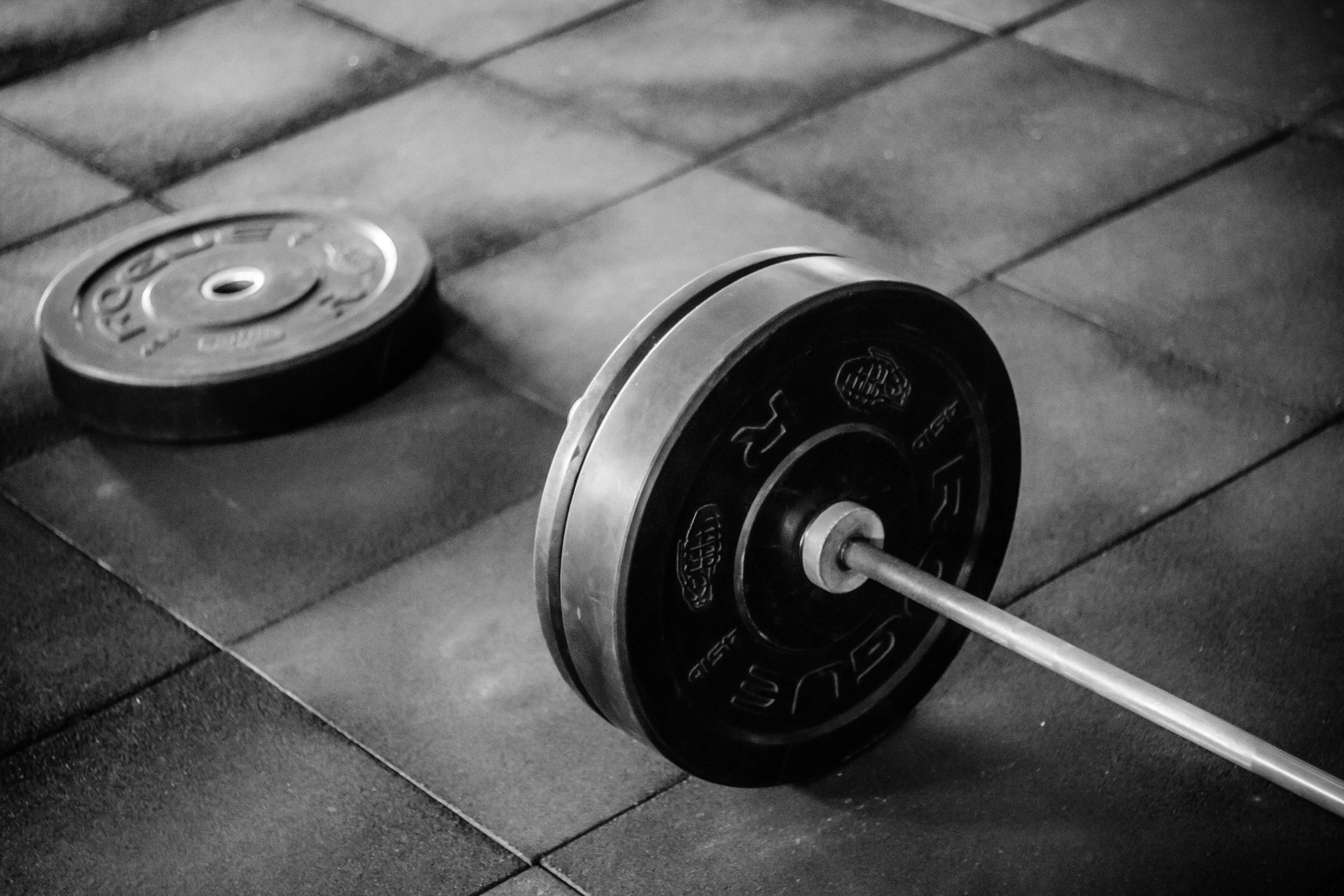 an exercise bench and dumbbell on a tiled floor