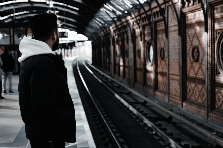 a man standing in a train station waiting for a train, pexels contest winner, thumbnail, facing away from camera, underground scene, profile picture 1024px