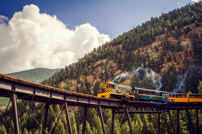 a train that is going over a bridge, by Doug Wildey, pexels contest winner, colorado mountains, 2 5 6 x 2 5 6 pixels, al fresco, golden engines