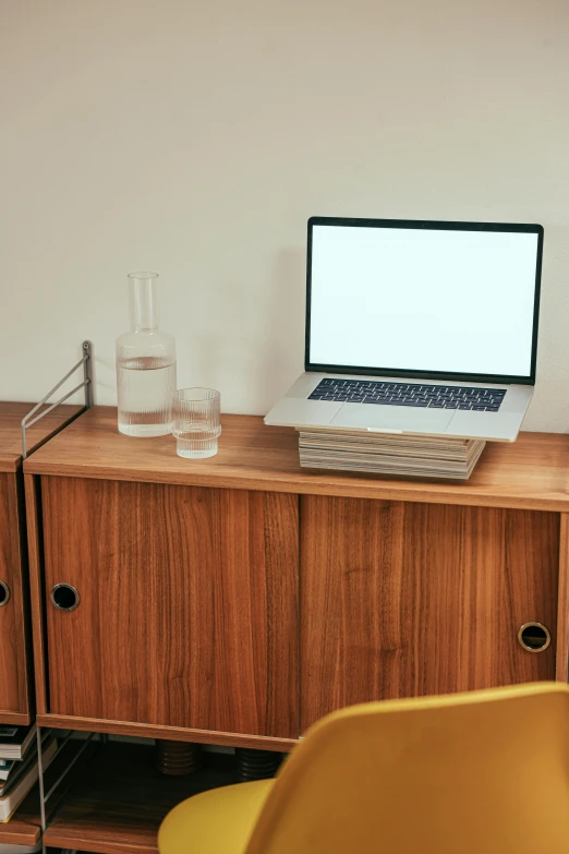 a laptop computer sitting on top of a wooden desk, by Carey Morris, small chest, minimalist lines, server in the middle, adult