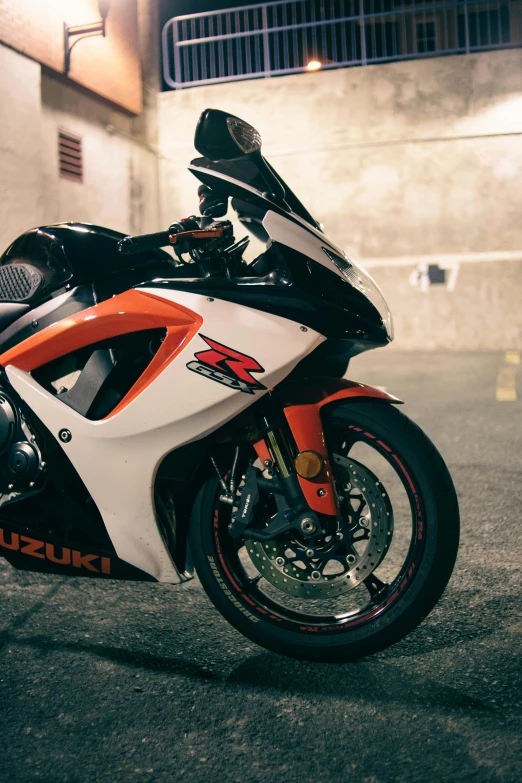 a motorcycle parked in a parking lot at night, a portrait, featured on reddit, white and orange, 2 5 6 x 2 5 6 pixels, up close shot, yoshimura exhaust