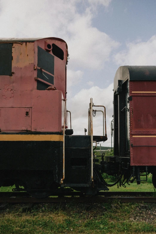 a couple of trains sitting on top of a train track, faded red and yelow, louisiana, square, museum