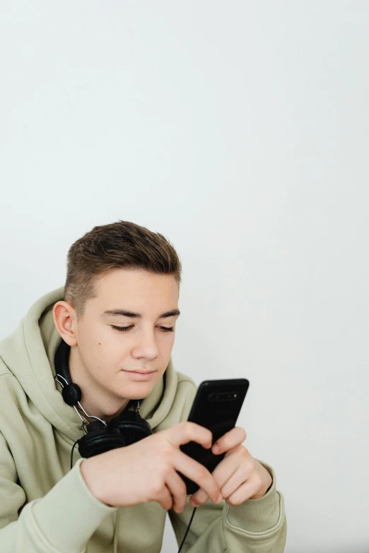 a man sitting at a table using a cell phone, discord profile picture, aged 13, high-quality photo, on a pale background