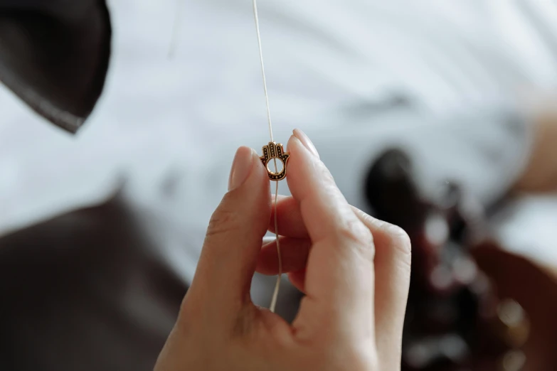 a close up of a person holding a string, jewelry photography, filling the frame, small crown, item