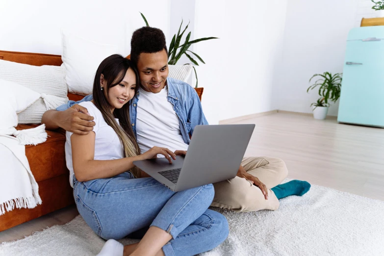 a man and woman sitting on the floor with a laptop, te pae, on a canva, pokimane, happy couple