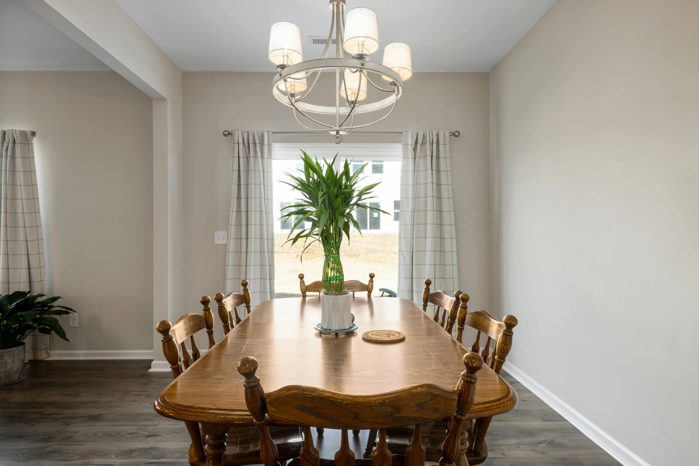 a dining room table with some chairs and plants in it