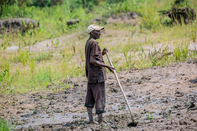 a man that is standing in the dirt, sweeping landscape, covered in mud, working hard, profile image