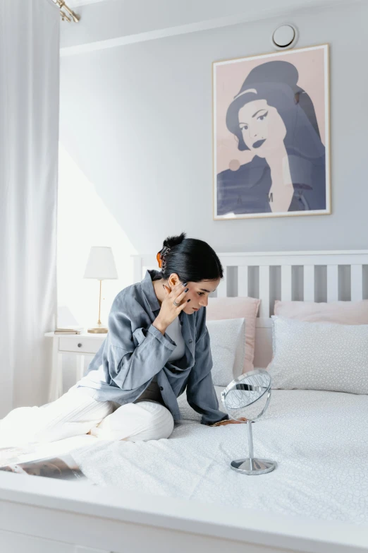 a woman sitting on a bed talking on a cell phone, inspired by Ruth Jên, trending on pexels, visual art, grey, asian female, pastel hues, pearl earring