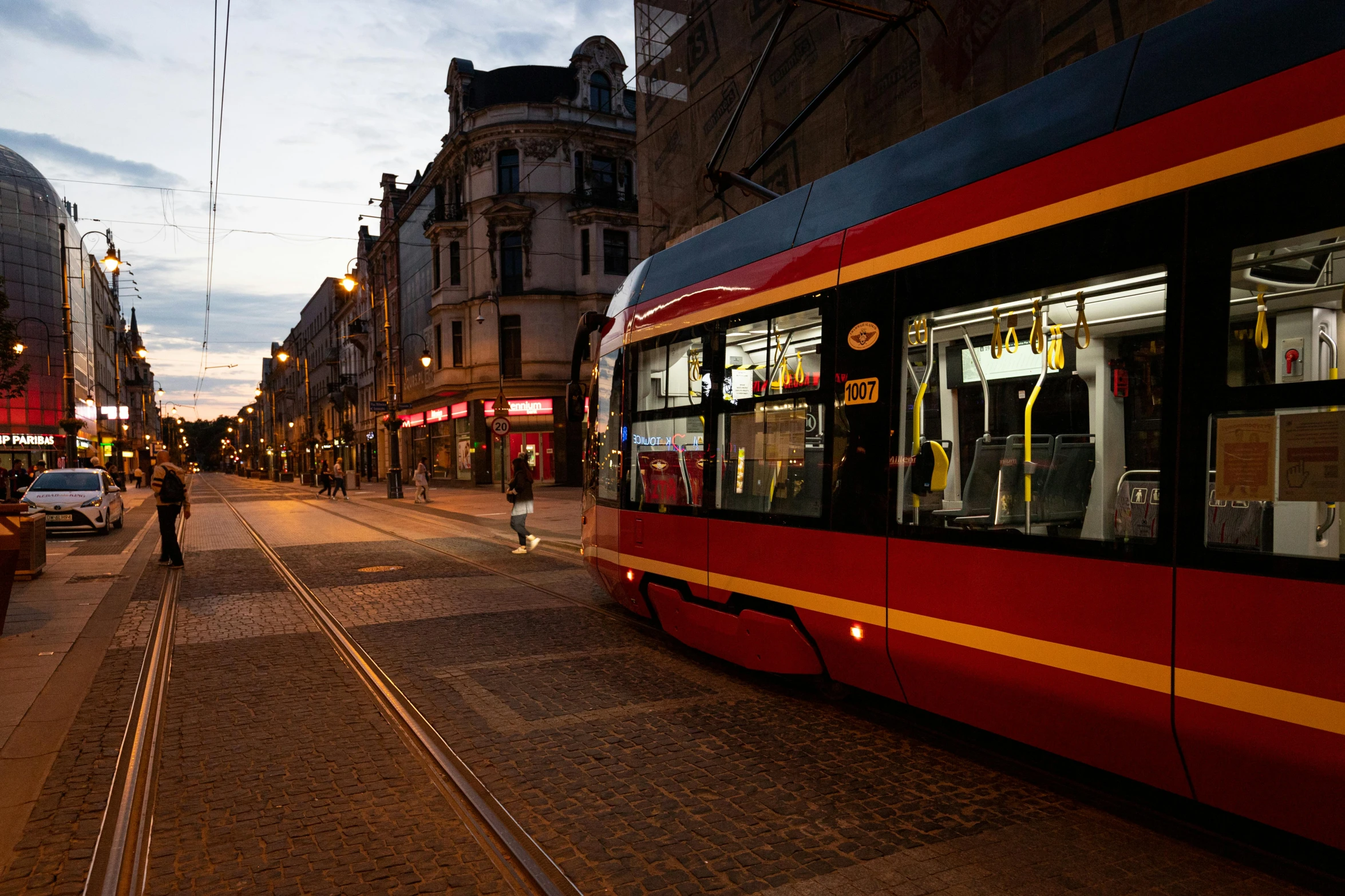 a person walking down the street next to a train