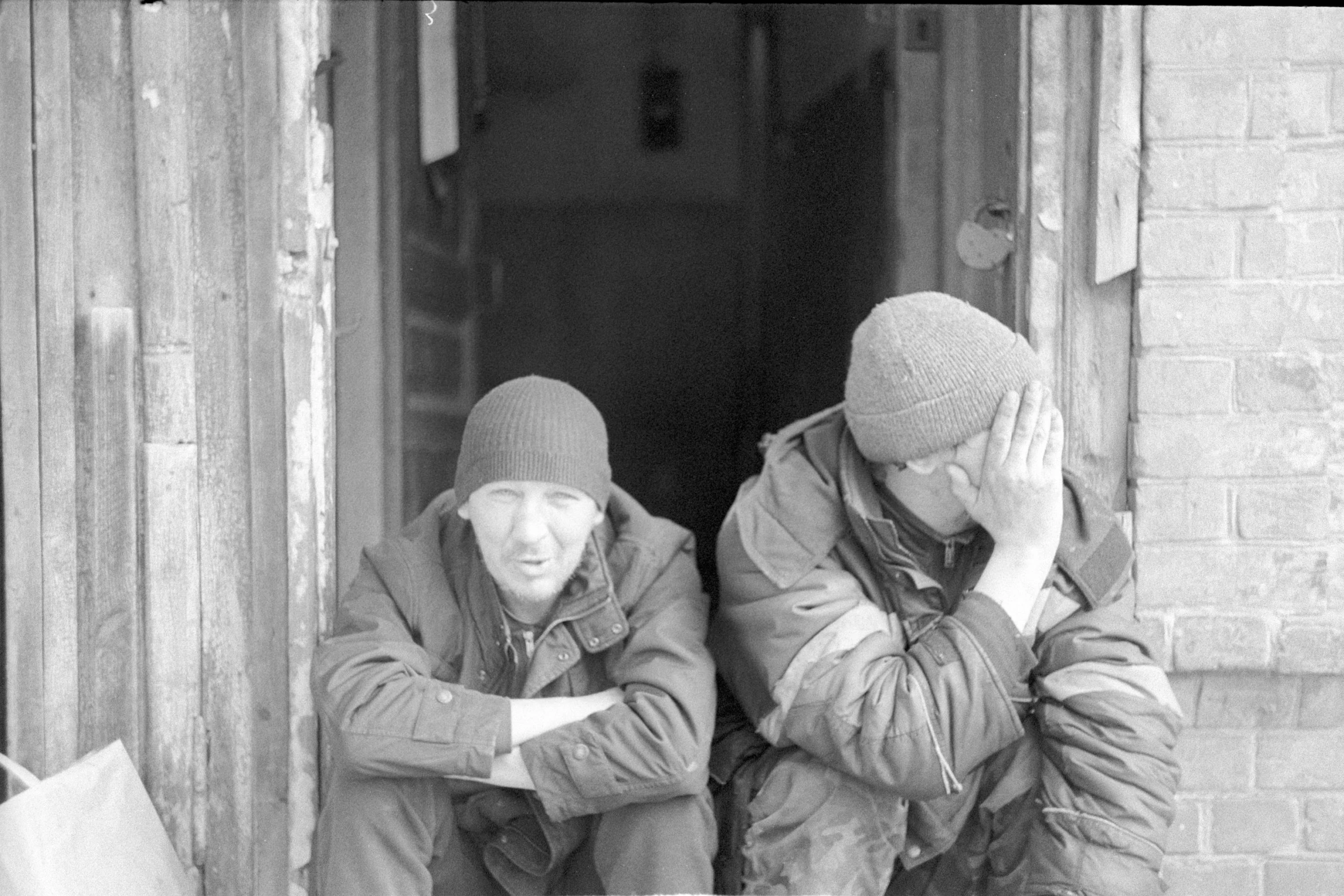 two men sitting on the steps of a building, a portrait, flickr, norilsk, berets, distraught, portrait image