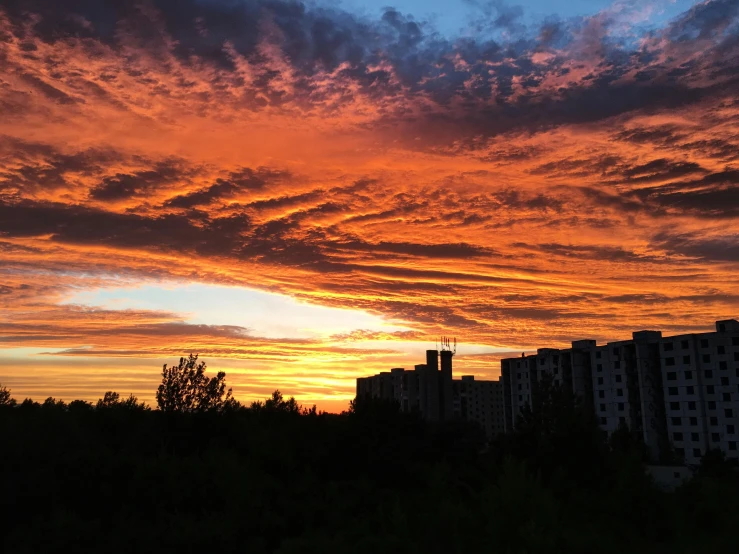 a sky filled with lots of clouds next to tall buildings, a picture, by Anato Finnstark, pexels contest winner, nebula sunset, # nofilter, anna nikonova, sky is orangish outside