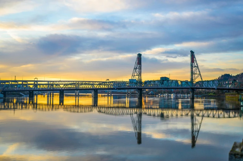 a bridge over a body of water under a cloudy sky, portland oregon, avatar image, golden hour photo, multiple stories