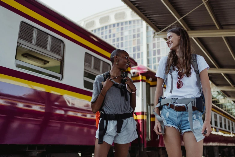 a couple of women standing next to a train, pexels contest winner, harnesses and garters, happy friend, beautiful city black woman only, sri lanka