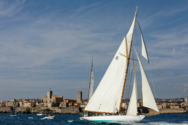 a sailboat in the water with a city in the background, by Simon Marmion, pexels contest winner, renaissance, slim aarons, cyan, belle epoque, thumbnail