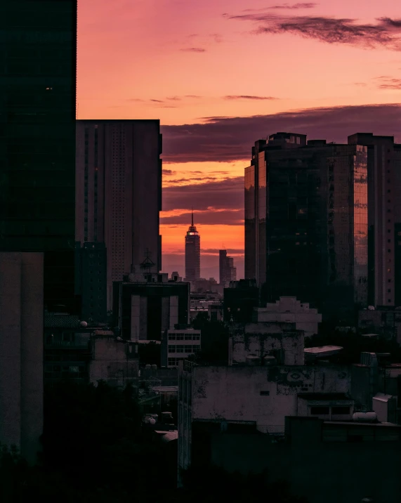 a view of a city at sunset with skyscrs