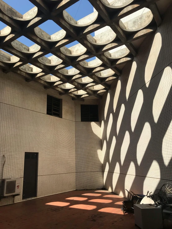 the sun shines through the roof of a building, by Yasushi Sugiyama, brutalism, light and shadow effects, courtyard, calarts, 2019 trending photo