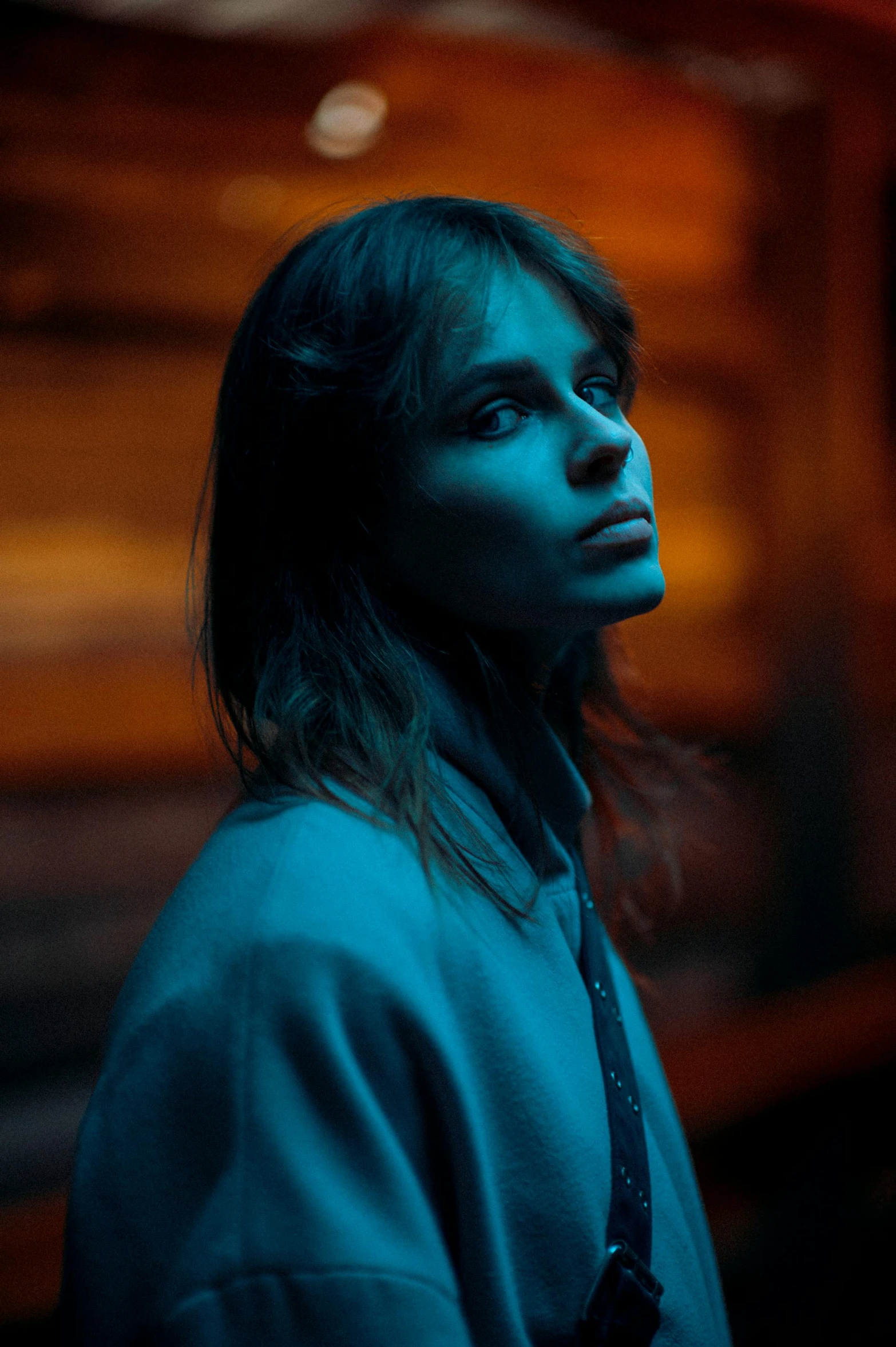 a woman standing in front of a train at night, a picture, inspired by Elsa Bleda, high cheekbones, dafne keen, dark. studio lighting, stood outside a wooden cabin