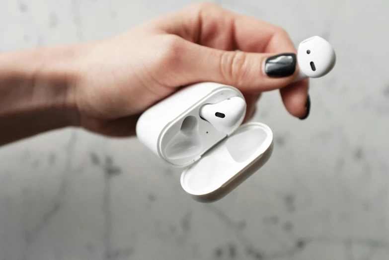 a person holding a pair of airpods in their hand, by Nina Hamnett, trending on pexels, square, white marble, uk, “hyper realistic