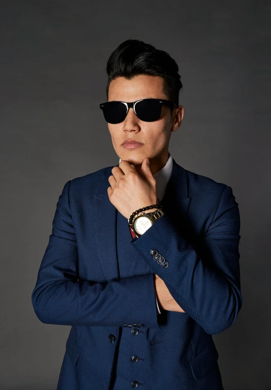 an asian man in a blue jacket is posing