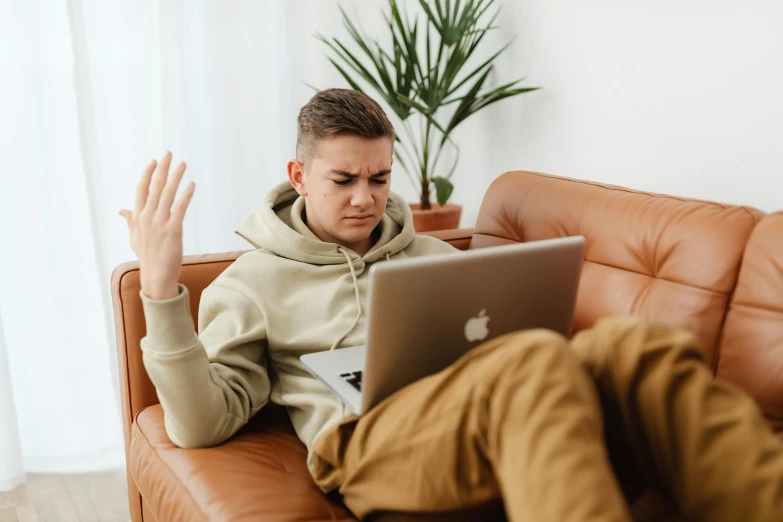 a man sitting on a couch using a laptop, trending on pexels, shrugging, male teenager, sitting on man's fingertip, avatar image