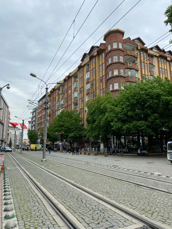 a train traveling down a city street next to tall buildings, berlin secession, cables everywhere, 🚿🗝📝, highly detailed 8k photo, helsinki