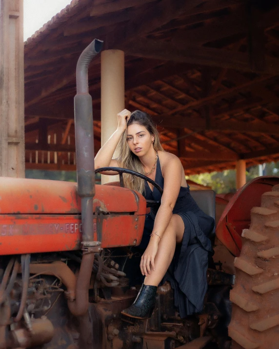 a woman sitting on top of a red tractor, pexels contest winner, brazilan supermodel, black and terracotta, on a farm, alanis guillen