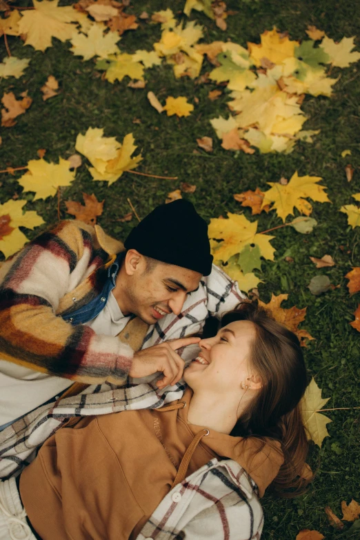 a man and a woman laying on a field of leaves, pexels contest winner, flirting, realistic footage, 1 4 9 3