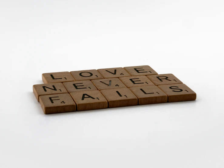 a scrabble that says love never fails, a jigsaw puzzle, inspired by Ian Hamilton Finlay, letterism, brown, press shot, multiple levels, tabletop miniature