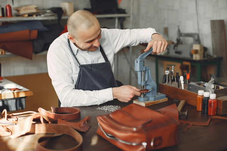 a man is working on a piece of leather, inspired by Mārtiņš Krūmiņš, trending on pexels, holding a briefcase, steel plating, press shot, thumbnail