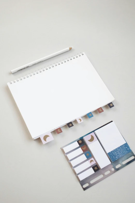 a notepad sitting on top of a desk next to a pencil, inspired by jeonseok lee, lunar color palette, contact sheet, white ceramic shapes, thumbnail