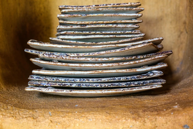 a stack of plates sitting on top of a wooden shelf, by Helen Stevenson, unsplash, renaissance, hand glazed pottery shards, closeup at the food, with ornamental edges, crackles