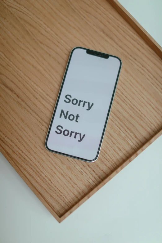 a cell phone sitting on top of a wooden tray, a picture, pixabay, modernism, don't be sad, sony nicon iphone 1 3 pro max, facepalm, minimalist sticker