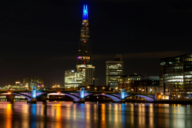 a view of london at night with the shard of the shard of the shard of the shard of the sha, an album cover, by Jay Hambidge, pexels contest winner, blue and orange rim lights, building along a river, thumbnail, london south bank