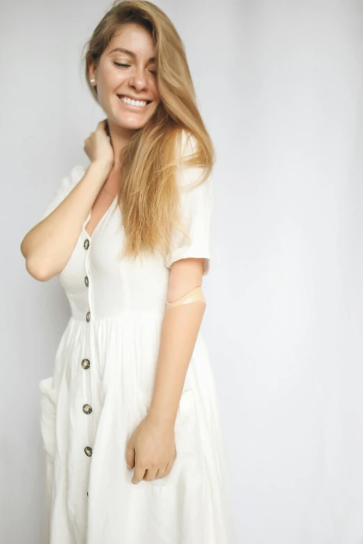 a woman in a white dress posing for a picture, smiling playfully, white background : 3, with long blond hair, 2019 trending photo