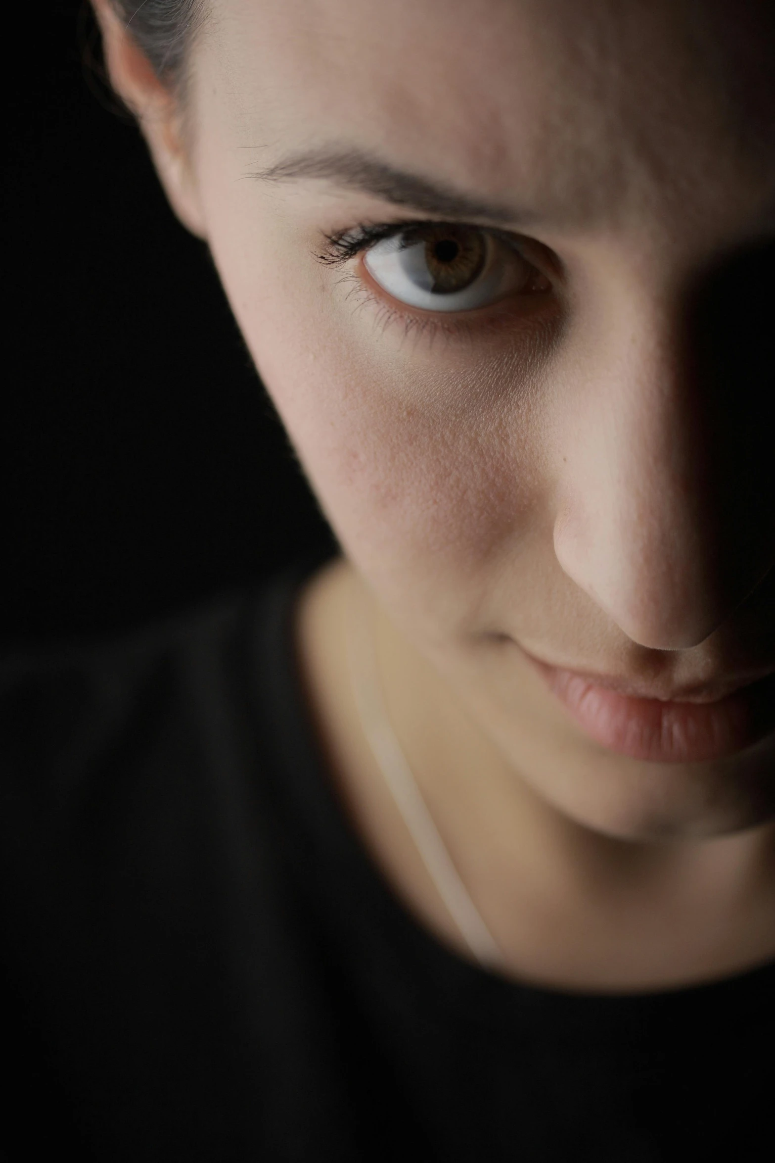a close up of a person with a cell phone, realistic face moody lighting, her face is in shadow, serious lighting, with a black background