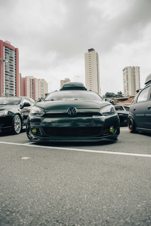 three black cars are lined up in a parking lot