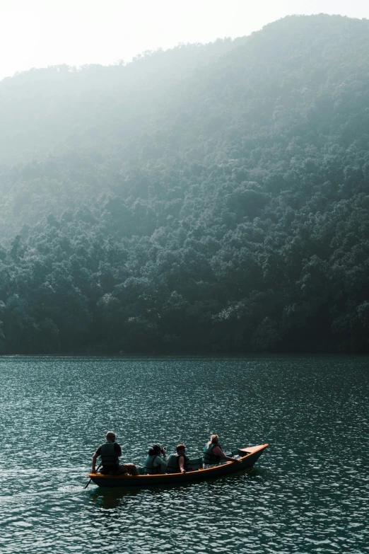 a group of people in a small boat on a lake, unsplash contest winner, sumatraism, indian forest, grey, lake blue, assamese aesthetic