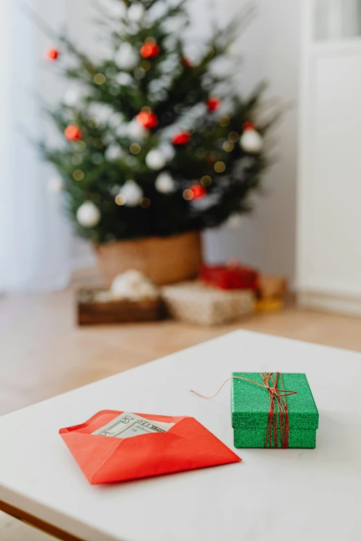 a little christmas tree near some presents sitting on a table