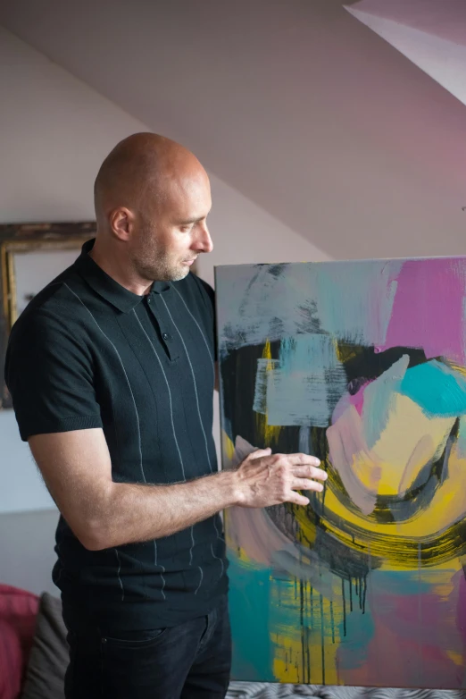 a man standing in front of a painting, inspired by Adam Pijnacker, pexels contest winner, abstract art, portrait of bald, in a studio, paul davey, profile portrait