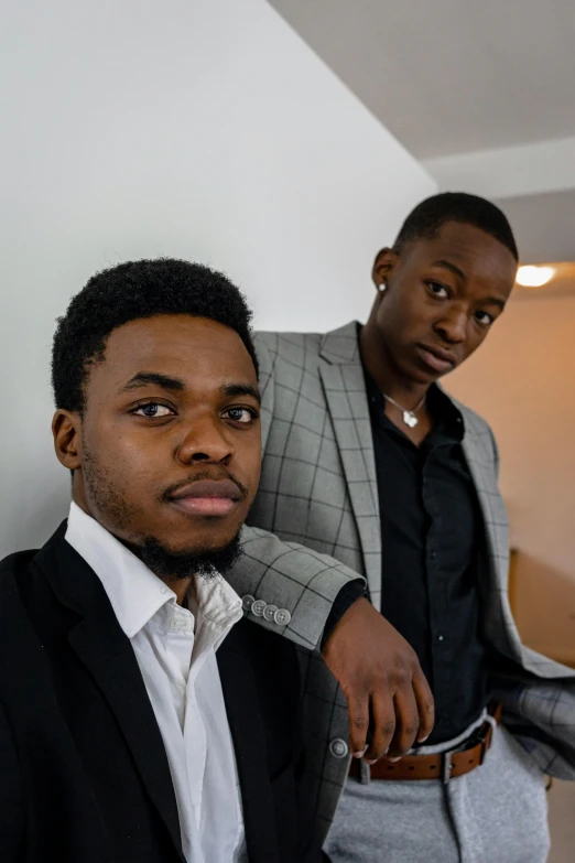 a couple of men standing next to each other, unsplash, black arts movement, wearing a suit and tie, serious and stern expression, the boys, ( ( theatrical ) )